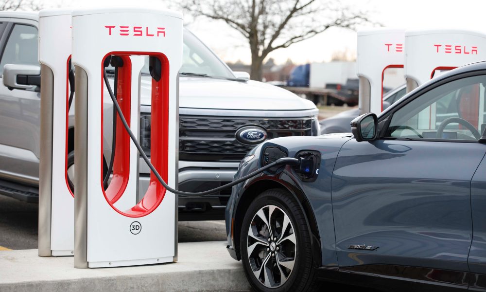 ford mustang mach-e plugged into a tesla supercharger