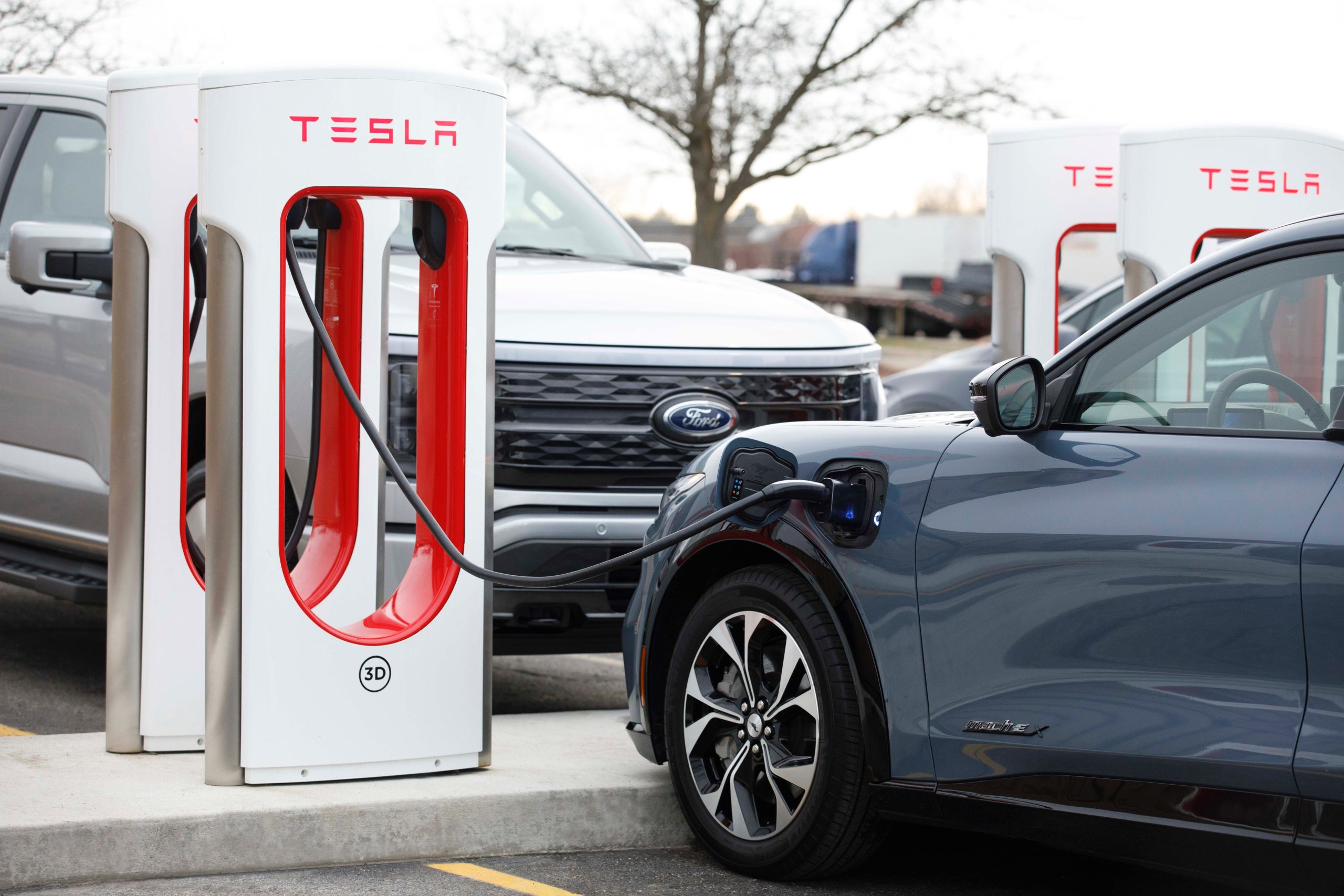 ford mustang mach-e plugged into a tesla supercharger