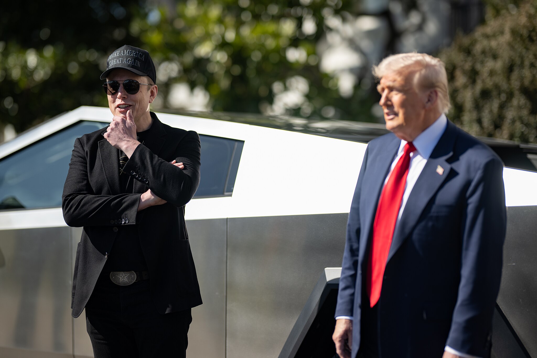 elon musk and donald trump in front of a tesla cybertruck at the white house